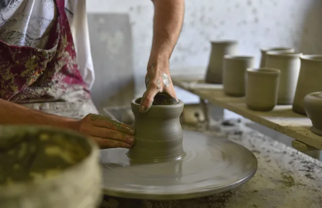 mani che lavorano la ceramica al tornio